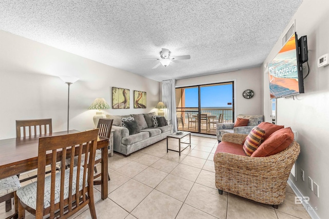 tiled living room with ceiling fan and a textured ceiling