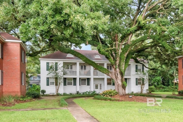 greek revival inspired property with a front yard