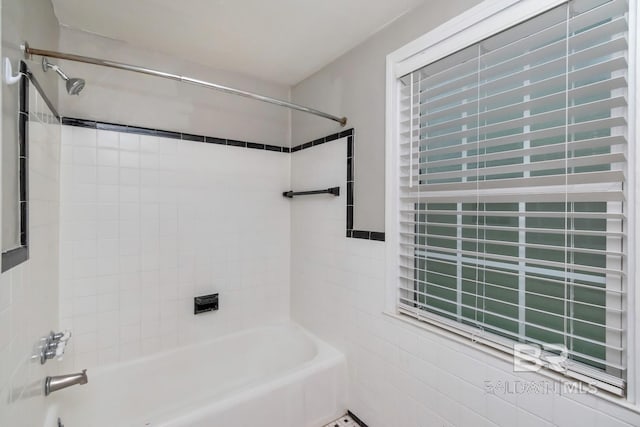 bathroom featuring tiled shower / bath combo and tile walls