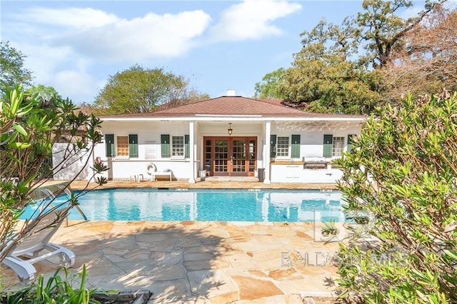 view of pool with french doors and a patio