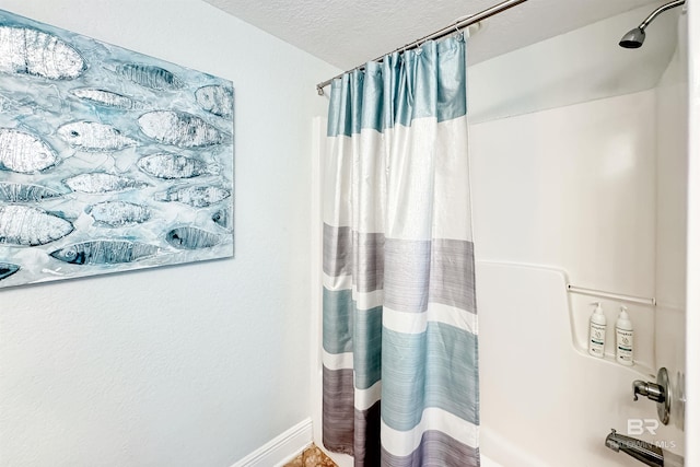 931 W Beach Blvd Unit 608, Gulf Shores, AL 36542 - bathroom featuring a textured ceiling, shower / bathtub combination with curtain, and baseboards