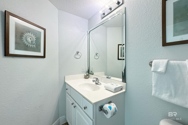 931 W Beach Blvd Unit 608, Gulf Shores, AL 36542 - bathroom featuring a textured wall, vanity, a textured ceiling, and toilet