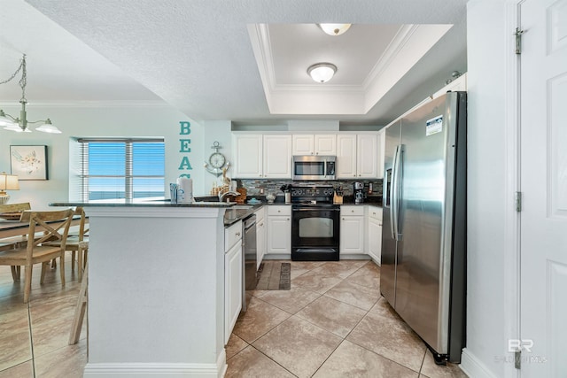 931 W Beach Blvd Unit 608, Gulf Shores, AL 36542 - kitchen with appliances with stainless steel finishes, crown molding, dark countertops, white cabinets, and a peninsula