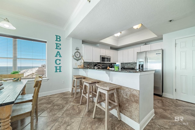 931 W Beach Blvd Unit 608, Gulf Shores, AL 36542 - kitchen featuring appliances with stainless steel finishes, ornamental molding, baseboards, tasteful backsplash, and white cabinets