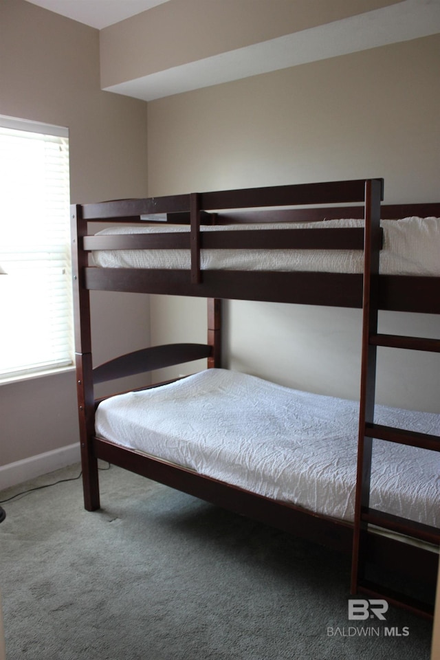 unfurnished bedroom featuring carpet flooring and multiple windows