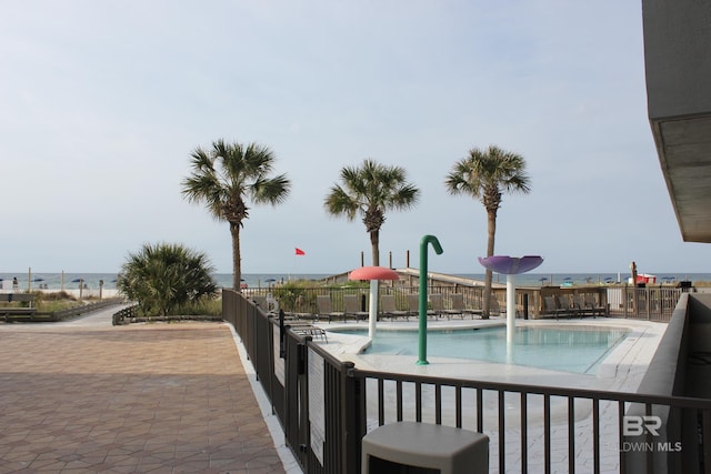 view of pool featuring a water view, a patio, and pool water feature