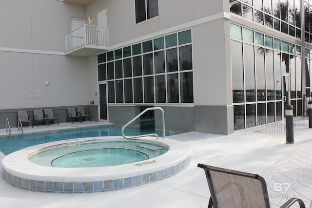 view of pool with a hot tub and a patio