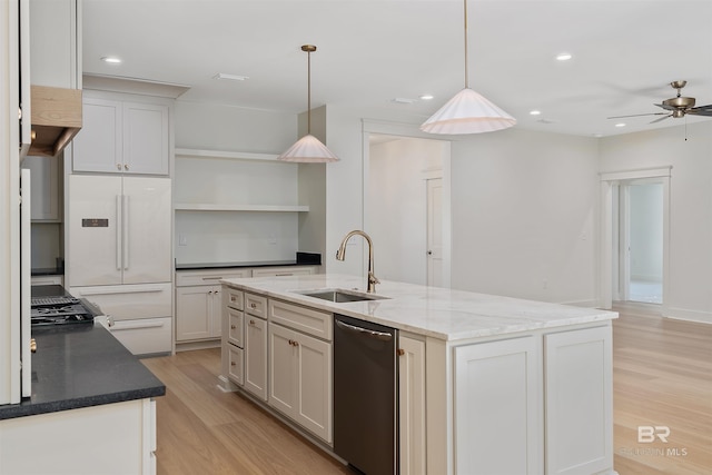 kitchen featuring stainless steel dishwasher, sink, pendant lighting, and light hardwood / wood-style floors