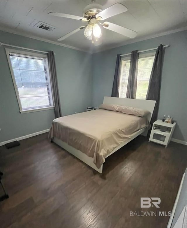 bedroom with multiple windows, crown molding, and dark hardwood / wood-style floors