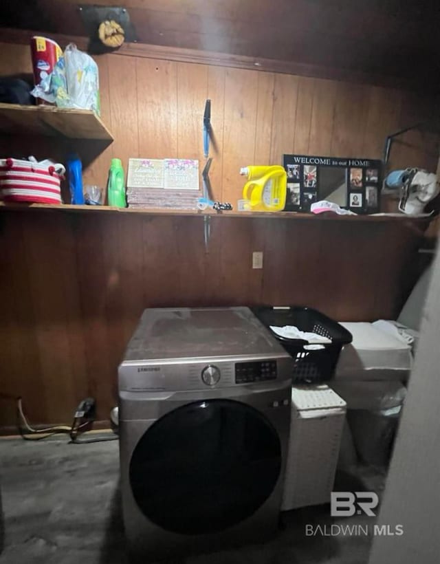 clothes washing area with washer / dryer and wooden walls