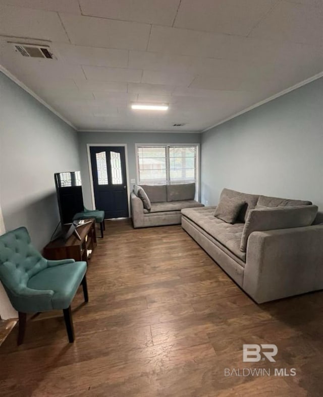 living room featuring hardwood / wood-style floors, crown molding, and a healthy amount of sunlight