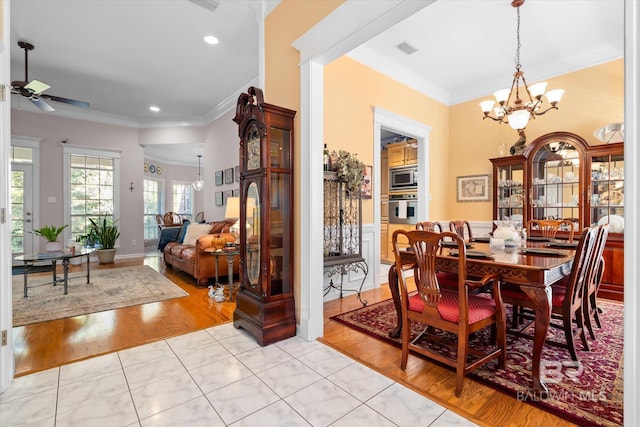 dining area featuring crown molding, light hardwood / wood-style flooring, and ceiling fan with notable chandelier