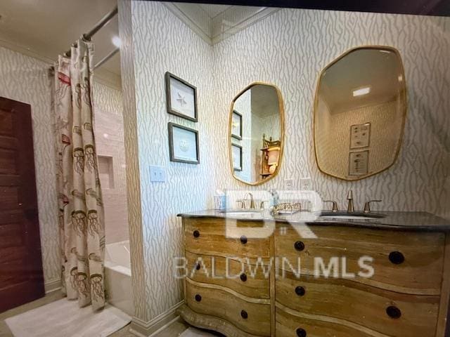 bathroom featuring a sink and wallpapered walls