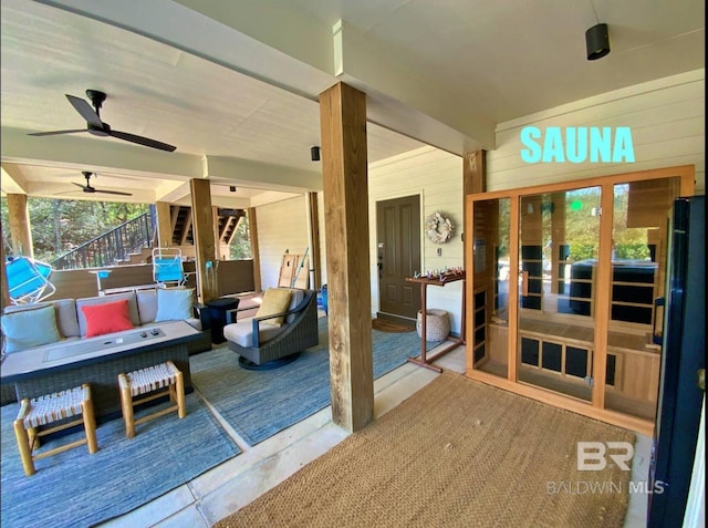 interior space featuring an outdoor hangout area, a ceiling fan, and stairs