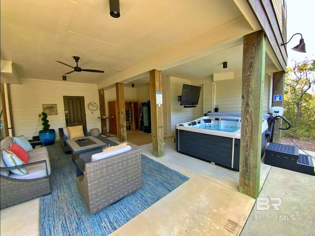 view of patio featuring ceiling fan, an outdoor living space, and a hot tub