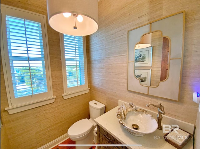 bathroom featuring vanity, toilet, and baseboards