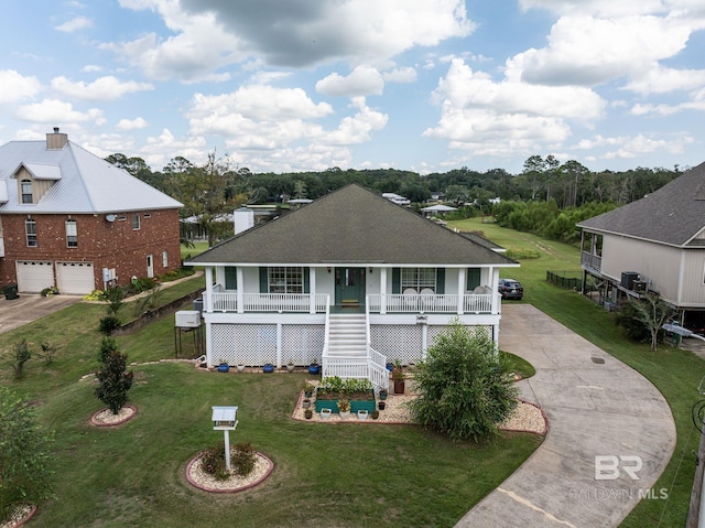 back of house featuring a lawn, a porch, and a garage