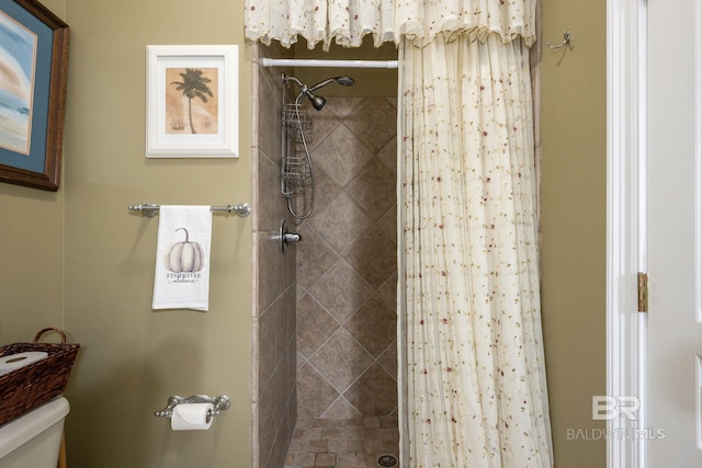 bathroom featuring toilet and curtained shower