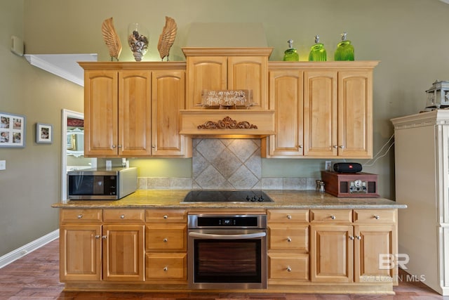 kitchen with appliances with stainless steel finishes, wood-type flooring, ornamental molding, and decorative backsplash