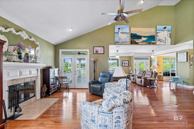 16288 Ferry Rd, Fairhope, AL 36532 - living area featuring french doors, a ceiling fan, a tiled fireplace, wood finished floors, and high vaulted ceiling