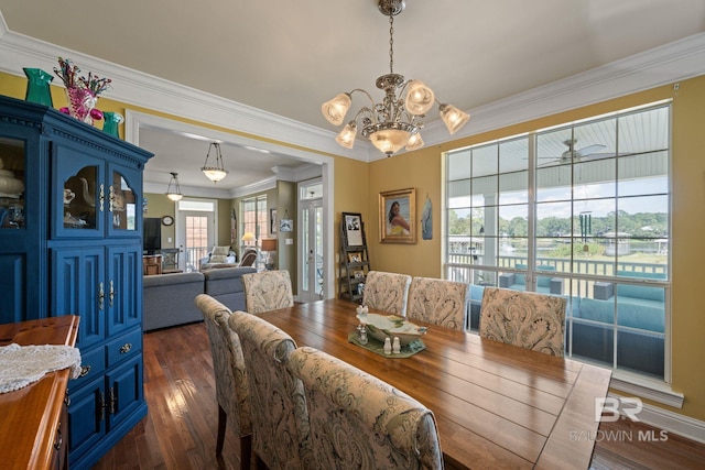 dining area featuring ceiling fan with notable chandelier, dark wood-type flooring, and ornamental molding