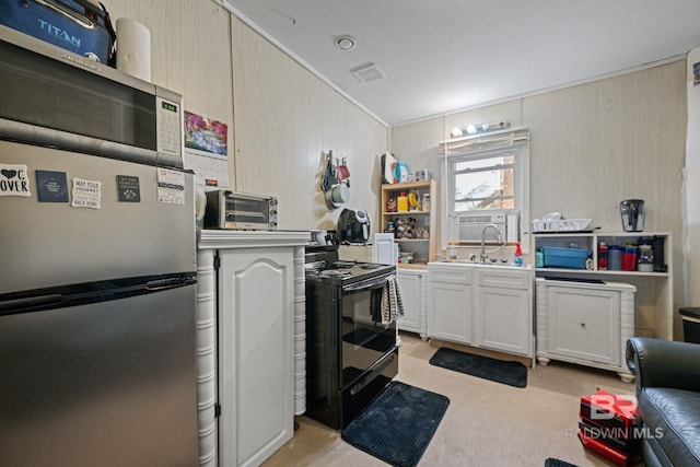 kitchen featuring light brown cabinetry, light colored carpet, electric range, and stainless steel refrigerator