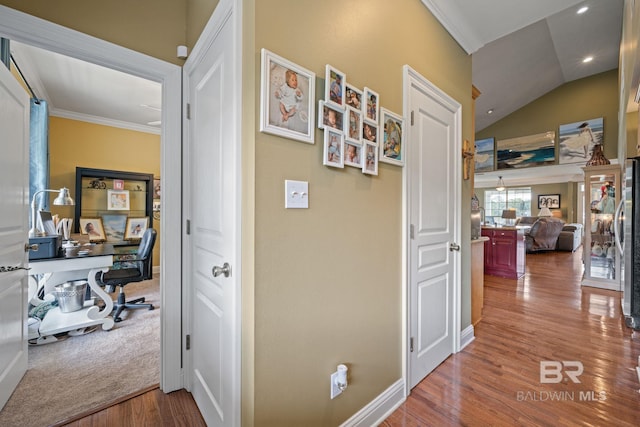 hallway featuring wood-type flooring, lofted ceiling, and crown molding