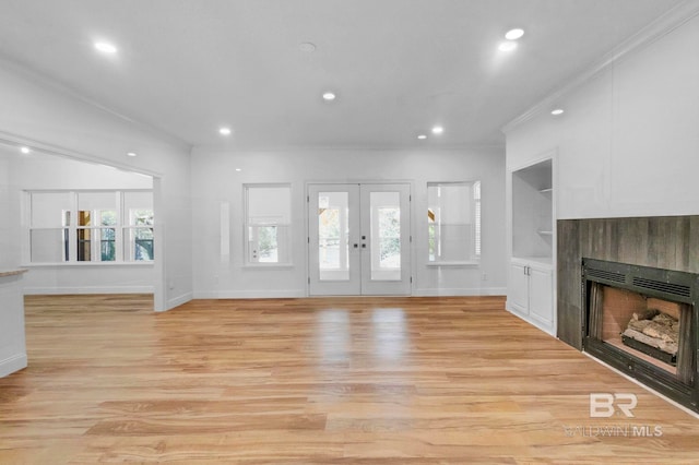 unfurnished living room with built in shelves, a fireplace, light wood-style floors, ornamental molding, and recessed lighting