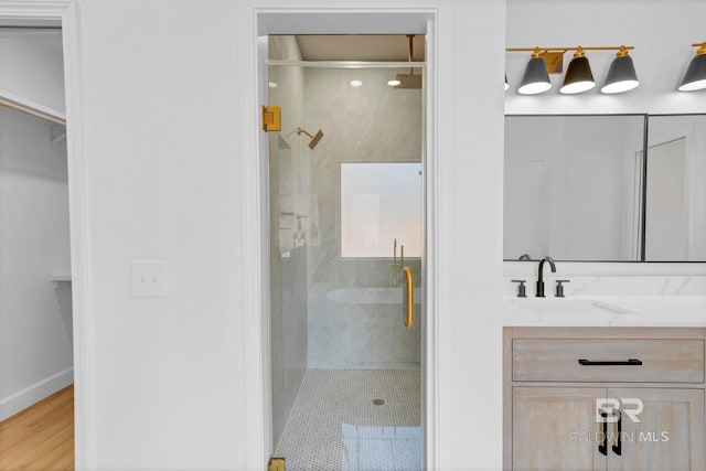 full bath with vanity, baseboards, wood finished floors, and a shower stall