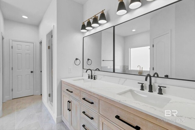 bathroom with marble finish floor, a sink, and double vanity