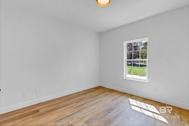 spare room featuring baseboards and wood finished floors
