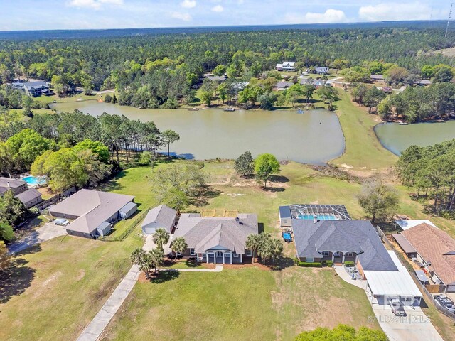 drone / aerial view featuring a forest view and a water view
