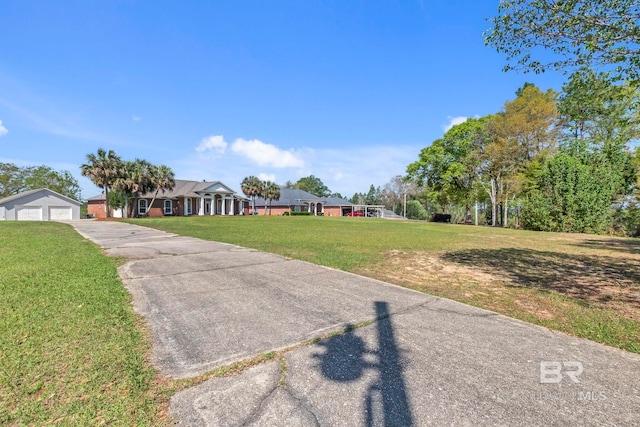 ranch-style house featuring a front lawn and a detached garage