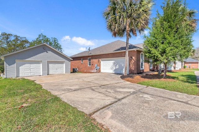 view of front of house featuring brick siding, an outbuilding, a front lawn, and a garage