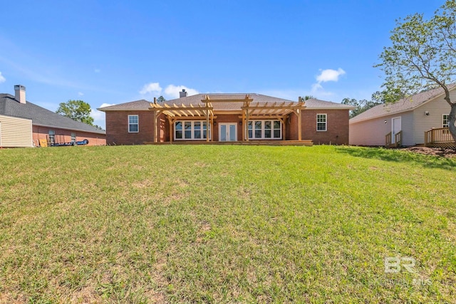 back of property featuring a yard, brick siding, and a pergola