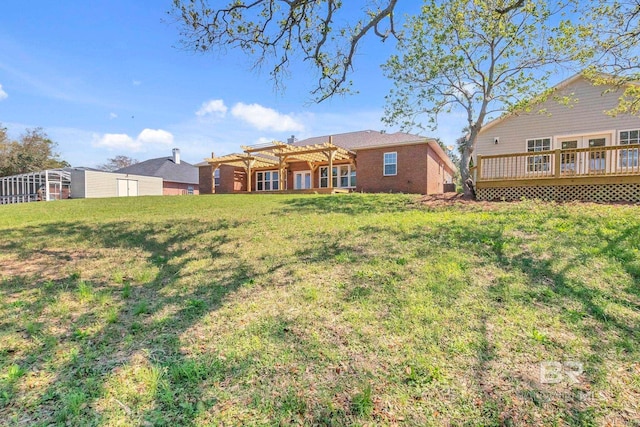 back of property featuring a pergola, a yard, and a wooden deck