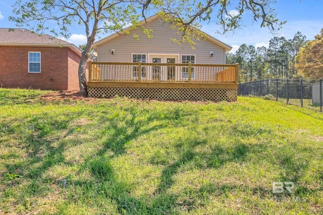 rear view of house featuring a deck, fence, and a yard