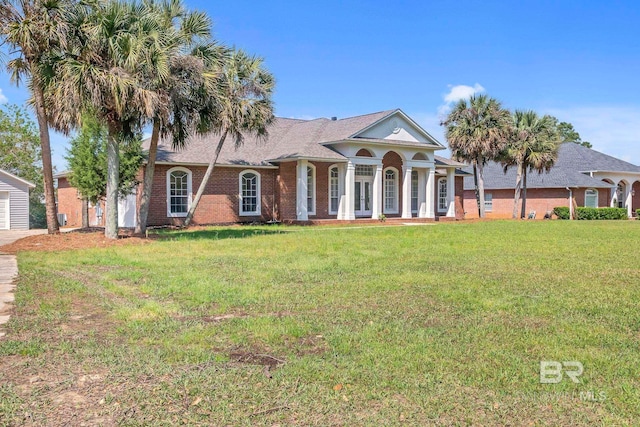 neoclassical home with french doors, brick siding, and a front lawn