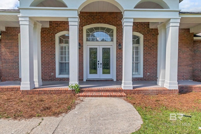 doorway to property featuring brick siding and french doors