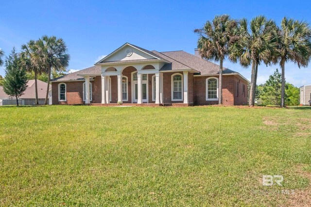 neoclassical home with a front yard and brick siding