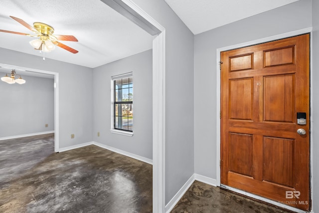 foyer entrance with ceiling fan with notable chandelier and a textured ceiling