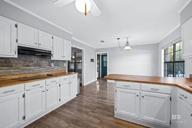 kitchen with white cabinetry, butcher block countertops, black electric stovetop, decorative backsplash, and crown molding