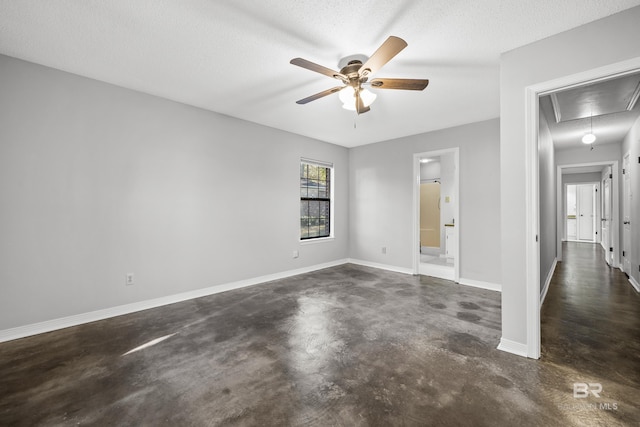 empty room with ceiling fan and a textured ceiling