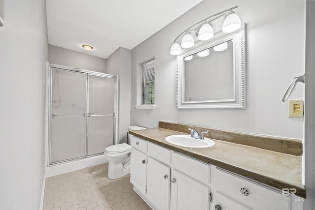 bathroom with walk in shower, vanity, tile patterned floors, and toilet