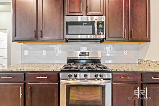 kitchen with backsplash, light stone countertops, and appliances with stainless steel finishes