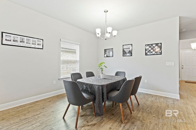 dining room with light wood-type flooring and a chandelier