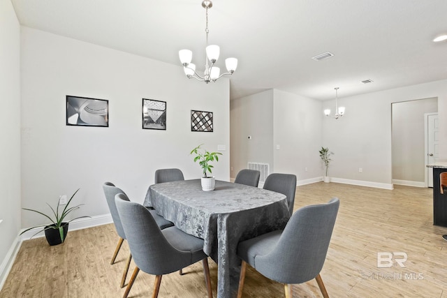 dining space with light wood-type flooring and a chandelier