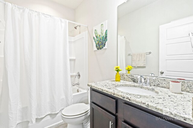 full bathroom featuring toilet, shower / bath combo with shower curtain, and vanity