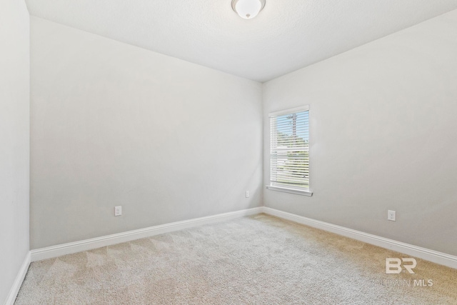 carpeted empty room with a textured ceiling