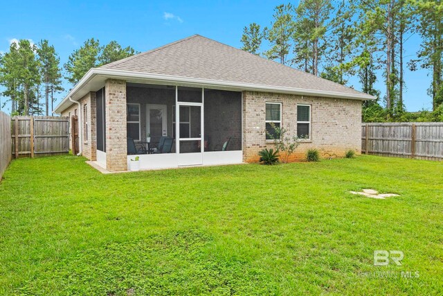 back of house featuring a lawn and a sunroom